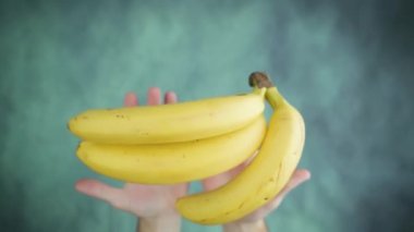 Erkek elleri kusar ve masanın üstünde olgun sarı muzlar yakalar.