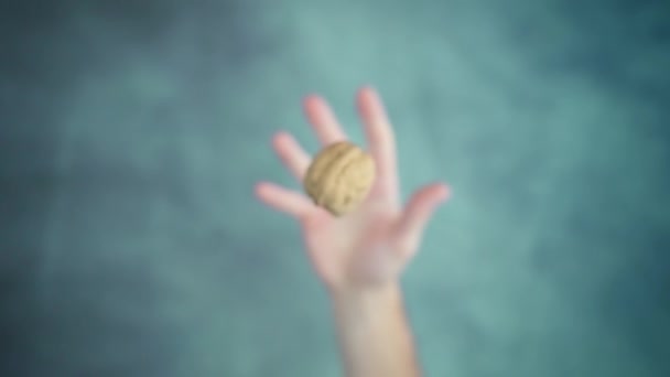 Person hand throwing up and catching walnut in nutshell — Vídeo de Stock