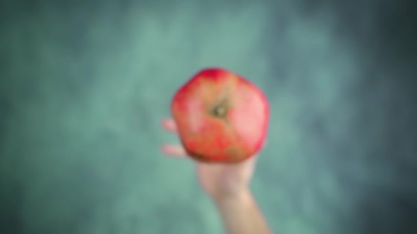 Throwing up and catching ripe red pomegranate above table — Stockvideo