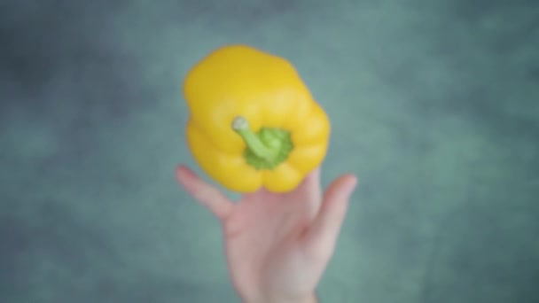 A pessoa vomita pimentão amarelo não cozido acima da mesa — Vídeo de Stock