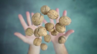 Kişi kusar ve iki eliyle fındık yakalar.