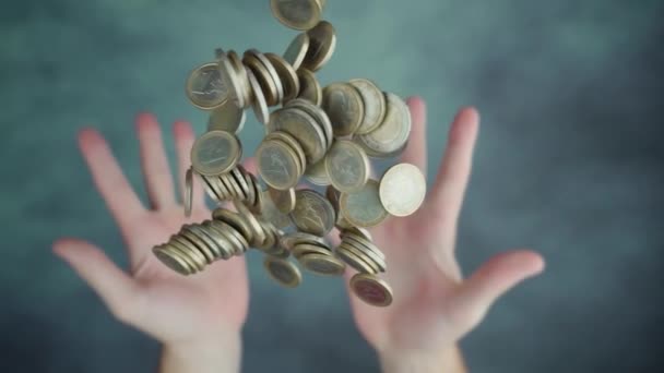 Hands throwing up handful of steel coins above table surface — Stockvideo