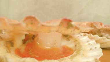 Benekli yumuşakça masanın üzerinde duran ince pembe kabuğu açar.