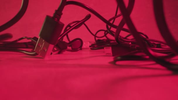 Tangled USB cords at red illumination of studio room — 图库视频影像