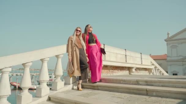 Meisjes in outfits poseren op brug over de Venetiaanse lagune — Stockvideo