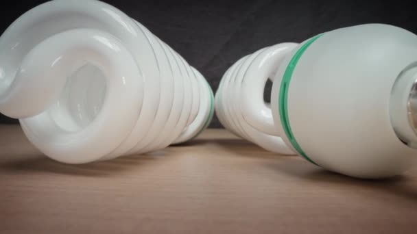 Energy-saving light bulbs on cardboard surface in studio — Stockvideo