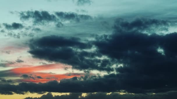 Σύννεφα που αιωρούνται στο φωτεινό χρώμα του ουρανού κατά το ηλιοβασίλεμα — Αρχείο Βίντεο