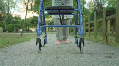 Yaşlı kadın, parkın yakınındaki ahşap çitlerin yanında yuvarlanıyor.