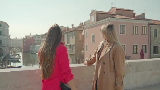 Young girl friends enjoy view on bridge over Venetian channel — Stockvideo