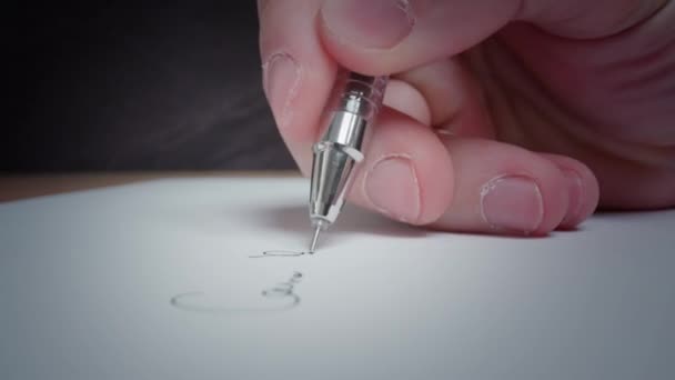 Man writes with black pen on white clean page lying on table — Vídeo de Stock
