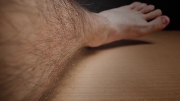 Cheveux longs foncés poussant sur la jambe masculine avec une peau claire macro — Video