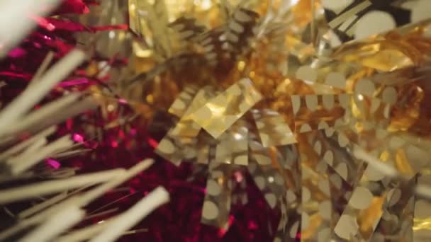 Motion though colorful foil Christmas tree tinsels in studio — Stock video