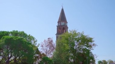 Tuğla çitli yüksek kilise çan kulesi park arasında duruyor.