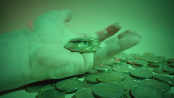 El hombre abre la palma con monedas de oro a la luz verde mística — Vídeo de stock