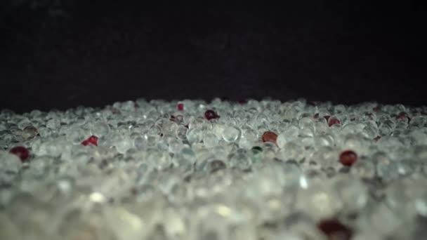 Motion over sparkling beads on black table in dark studio — Stock video