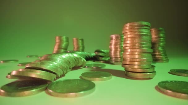 Montones de monedas caen sobre la mesa a la suave luz verde — Vídeos de Stock