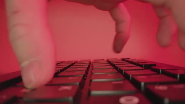 Person types fast on keyboard working at table on red — Vídeo de Stock