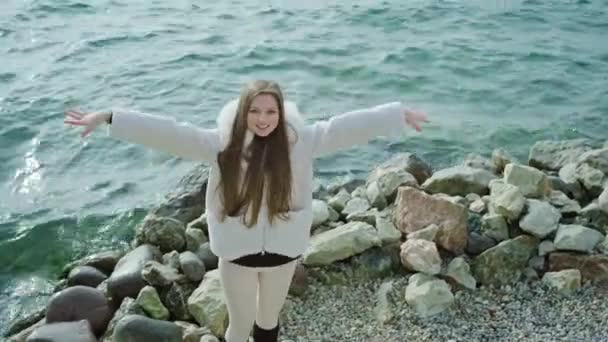幸せな女性は湖のほとりで風をキャッチ手を上げる — ストック動画