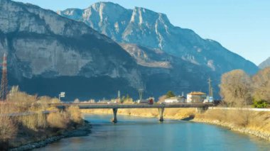 Arabalar köprüden nehrin üzerinden kayalık dağlara doğru gidiyor.