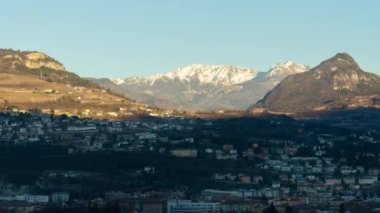 Dağ gölgesi Trento 'yu dev ormancılık dağlarına karşı küçük binalarla kaplıyor. Sonbahar günü mavi gökyüzü altındaki antik İtalyan şehri