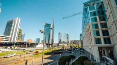 MILAN, İtalya - 11 Nisan 2022: güneşli bir günde Milano 'da modern yüksek katlı cam binalarla dolu bir cadde. İtalya 'nın merkezindeki lüks mimari 11 Nisan' da Milano 'da hiper kayma yaşadı.