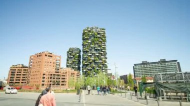 MILAN, ITALY - 11 Nisan 2022: Yol Milano 'nun merkezinde mavi gökyüzüne karşı dikey ormanı olan yüksek binalara çıkıyor.