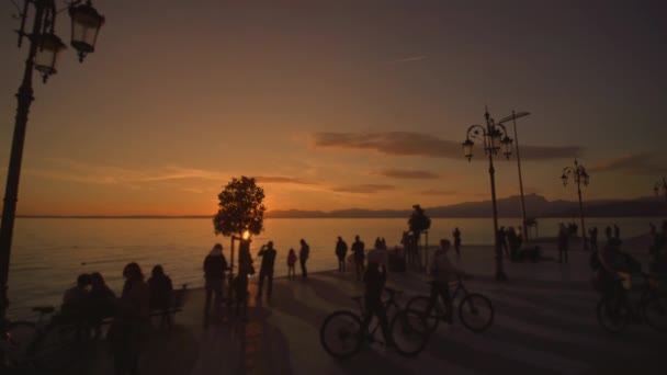 Tourists Enjoy Watching Bright Sunset City Waterfront Lake Garda Late — Αρχείο Βίντεο