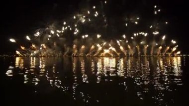 Yellow and blue fireworks burst from water over night city on Feast of Redeemer. Entertainment for citizens on traditional holiday in Venice