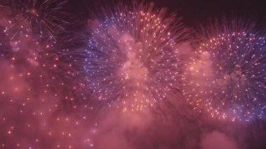 Bright red and blue fireworks explode in dark night sky at Feast of Redeemer. Incredible show with salute due to holiday celebration in Venice