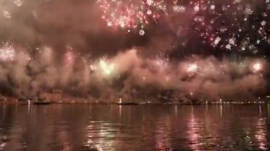 Colorful fireworks burst in air reflecting on water surface in Venice. Traditional firework show at Feast of Redeemer on summer evening