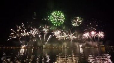 Traditional show with bright colorful fireworks bursting in air over city reflecting on water. Celebration of Feast of Redeemer in Venice