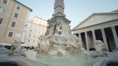 ROME, ITALY - MAY 12 2022: Fountain with extraordinary sculptures against Pantheon in Rome under blue sky. Ancient architecture in touristic city close view on May 12 in Rome