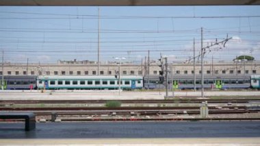 ROME, ITALY - MAY 12 2022: Passenger train goes on railroad departing from railway Termini station in Rome. Infrastructure of Italian capital on sunny day on May 12 in Rome