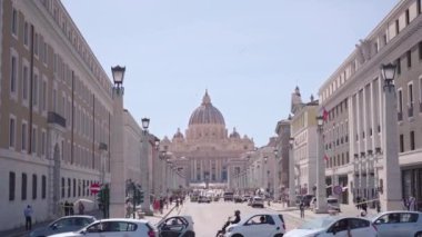 ROME, ITALY - MAY 12 2022: Road leads to St Peter square and Basilica in Vatican on sunny day. Ancient architecture with old catholic Cathedral in city-state on May 12 in Rome