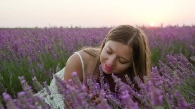 Woman smells lavender in the sunset