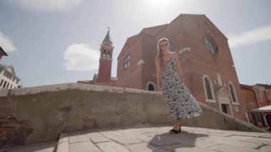 Woman has fun dancing on the bridge in Venice in the summer