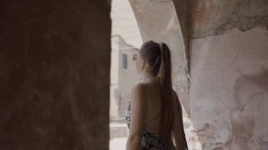Steady woman looks at the city under the arcades of Venice