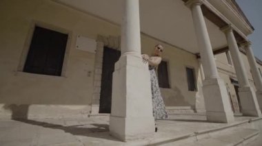 Donna moves hiding behind the column of the Venetian palace