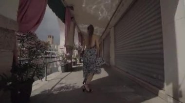 Woman dances while having fun under the ancient houses of Venice