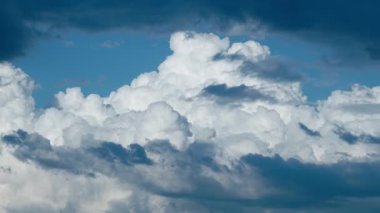 Heavy white and dark blue clouds cover clear blue sky before thunderstorm on summer day. Scenic cumulus cloudscape as background time lapse