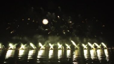 Bright fireworks launched in turn over city reflecting on water surface at night in Venice. Traditional show at end of Feast of Redeemer celebration