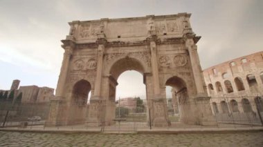 Large Triumphal arch attracts tourists in center of Rome near Colosseum. Cultural heritage and ancient architecture of Italian capital in early morning