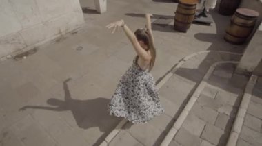 Woman moves dancing on the ancient street of Venice