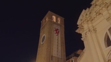 CHIOGGIA, İtalya - 18 Ağustos 2022: Marciliana 'daki St. Andrew Kule Saati Chioggia' daki karanlık gökyüzüne karşı. İtalyan kasabasının antik mimarisi 18 Ağustos 'ta Chioggia' da alçak açılı çekim yaptı.