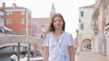 Antik şehir Chioggia 'da arkasında köprü ve kule olan bir kadın.