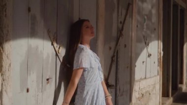 Kanal suyunun yansımalarıyla antik Venedik duvarının önündeki kadın.