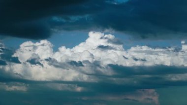 Ağır beyaz ve koyu mavi kümülüs bulutları açık mavi gökyüzünde yaz günü süzülür. Fırtınalı hava ve bulutlu zemin zaman aşımı olarak