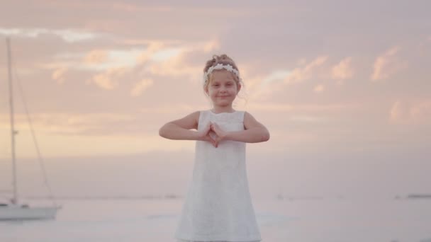 Liten Flicka Visar Hjärta Symbol Med Händer Vid Soluppgången Över — Stockvideo