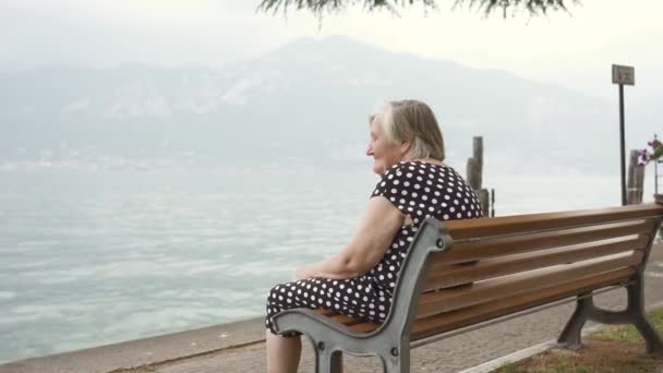 Die Seniorin Gepunkteten Kleid Ruht Auf Einer Holzbank Ufer Und — Stockvideo