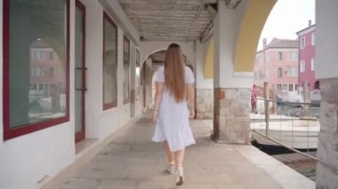 Kadınlar yazın Venedik evlerinin antik kemerlerinin altında yürürler.